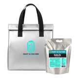 A silver insulated tote labeled “Craft & Culture” sits beside a silver pouch of 8 Day Kombucha “Bloat No More” Detox from Craft & Culture - Kombucha, Kefir & Probiotics Singapore, known for bloat relief.