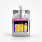 A silver pouch with a white cap, labeled “Craft & Culture - Kombucha, Kefir & Probiotics Singapore [SAMPLER 6] Whole Milk Kefir.” The probiotic drink features purple and yellow labels with product details and nutrition facts.