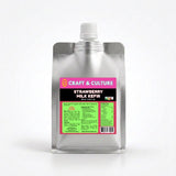 A silver pouch with a white cap labeled “Strawberry Whole Milk Kefir” from Craft & Culture - Kombucha, Kefir & Probiotics Singapore stands upright, featuring a pink and green label against a plain white background.